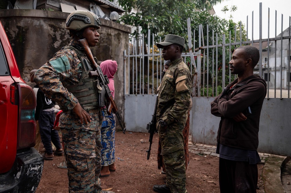 M23 members stand guard near a private residence damaged by a drone strike in Goma on March 11, 2026. (AFP)