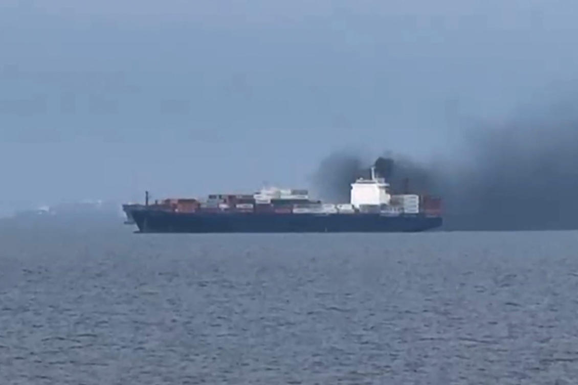 This frame grab from handout UGC video footage by seafarer Wang Shang taken on March 12, 2026 and released to AFPTV on March 13 shows smoke emerging from the Source Blessing cargo vessel, as filmed from the vessel Wang was onboard in the Gulf, north of Dubai. (AFP)
