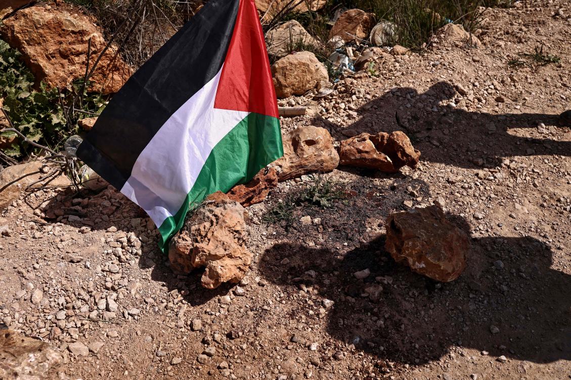 A Palestinian flag is placed at the site where a Jewish settlers' attack killed 3 Palestinians and injured 7 others on March 8, in the village of Abu Falah, northeast of Ramallah in the Israeli-occupied West Bank on March 12, 2026. (AFP)
