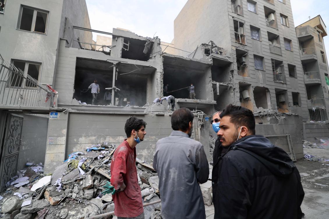 Iranians look on as others clear the debris from damaged homes in the Iranian capital Tehran on March 15, 2026. Iran’s Foreign Minister said in an interview published on March 15, that the war pitting his country against the United States and Israel will only end when Tehran can be certain it will not be restarted (AFP)