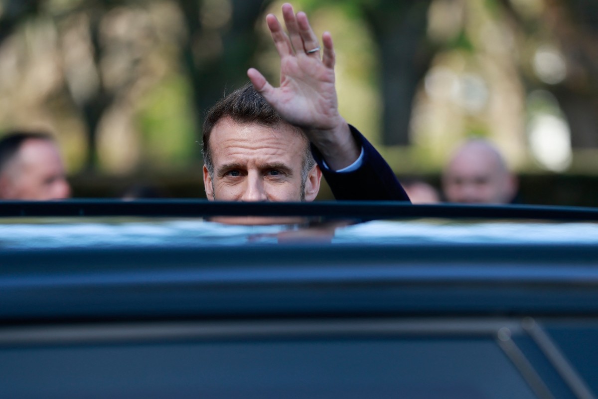 French President Emmanuel Macron waves at bystanders as he leaves the polling station in Le Touquet, France, (AFP)
