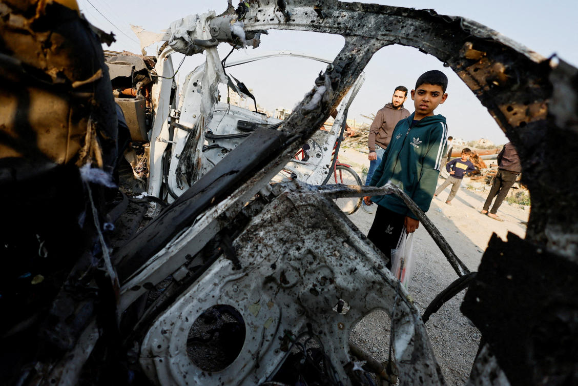Palestinians inspect the site of an Israeli airstrike targeting a police vehicle in the central Gaza Strip, March 15, 2026. (REUTERS)
