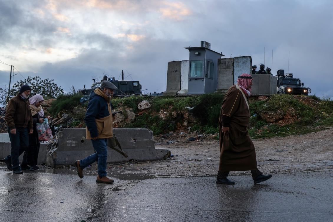Israeli security forces keep watch as Palestinian Muslims cross the Qalandia checkpoint in the occupied West Bank city of Ramallah early on February 27, 2026, on their way to the al-Aqsa Mosque in Jerusalem for the second Friday noon prayers of Islam's holy month of Ramadan. (FILE/AFP)