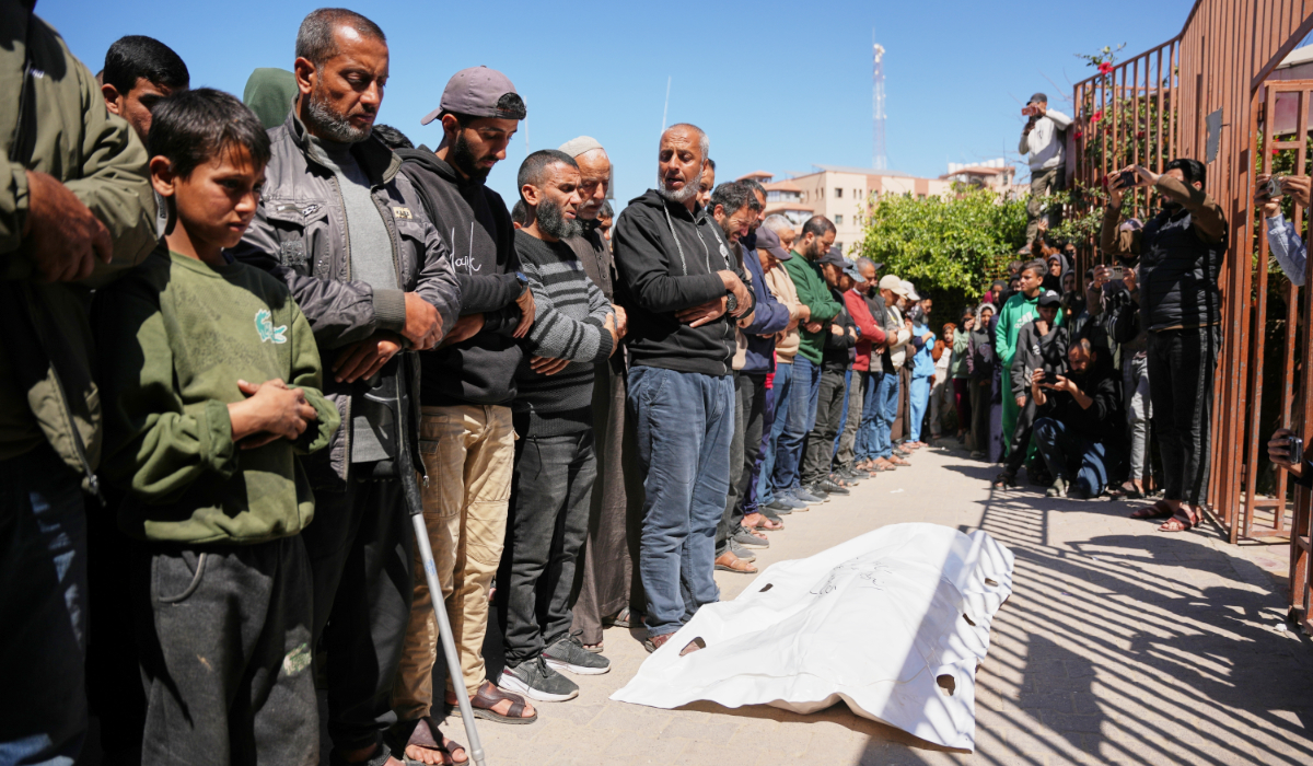 Mourners pray over the body of Yahya Abu Labda, who was killed in an Israeli strike, at Nasser Hospital in the southern Gaza Strip, Tuesday, March 17, 2026. (AP)
