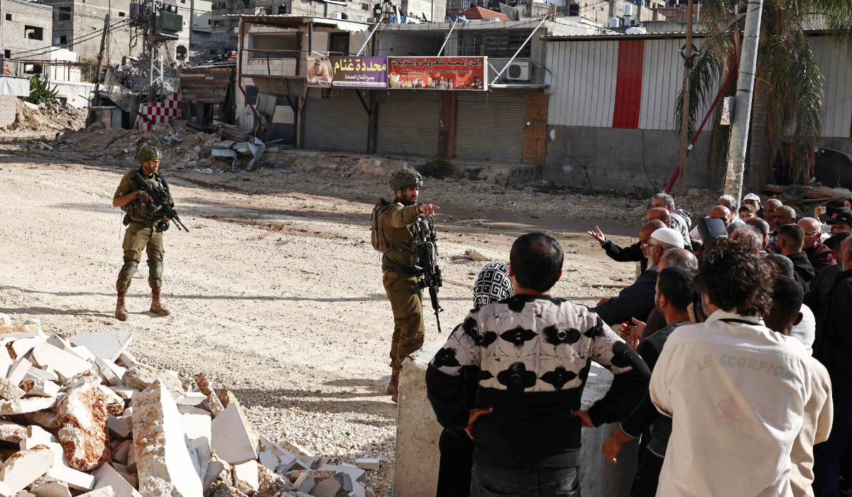Residents of the Nur Shams refugee camp, near Tulkarem in the Israeli-occupied West Bank, argue with Israeli soldiers as they protest at the entrance of the camp demanding the right to return to their homes, on November 18, 2025. (AFP)