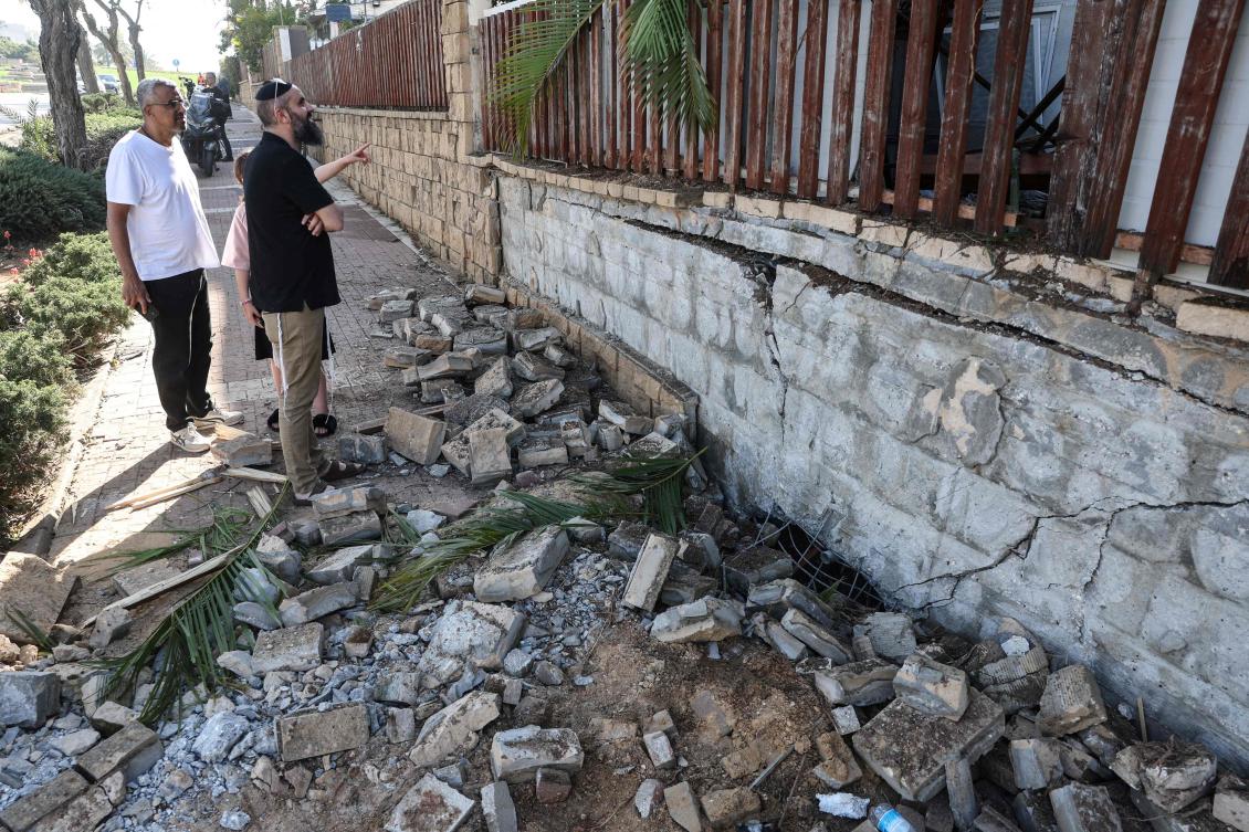 Israelis gather to look at the damage to a house at the site of a strike that hit a residential neighborhood in Rishon Letzion area on Mar. 17, 2026. (AFP)