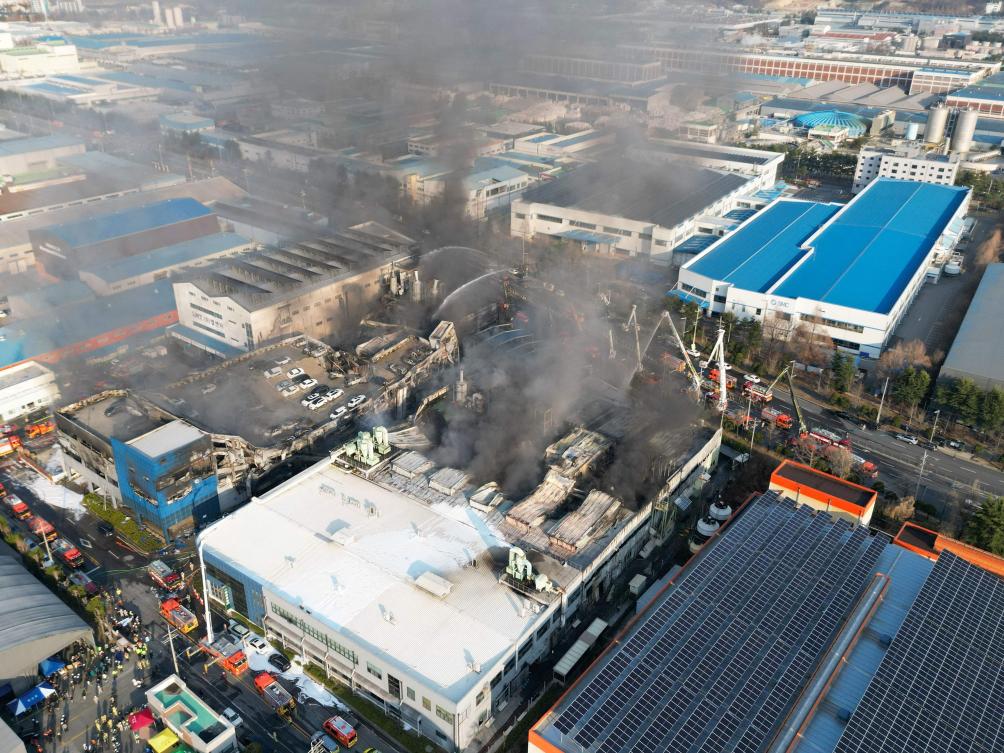 Above, firefighters spray water to extinguish a fire at a car parts plant in Daejeon on March 20, 2026. (Yonhap/AFP)