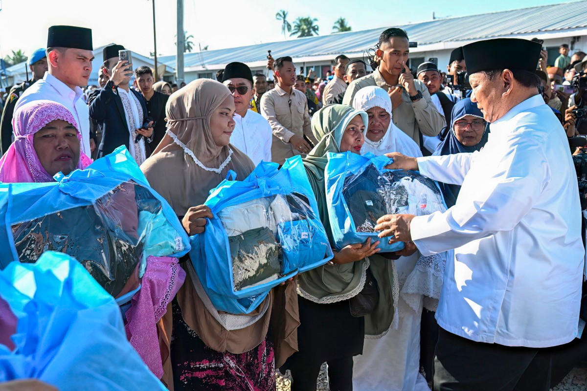 This handout picture taken and released on March 21, 2026 shows Indonesian President Prabowo Subianto distributing aid to survivors of Sumatra floods in Aceh Tamiang, Aceh. (Indonesia’s Presidential Palace/AFP)