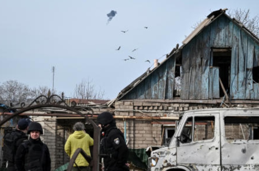 Ukrainian servicemen hit a Russian drone as police officers work at the site of a building hit by a Russian drone strike in Zaporizhzhia, Ukraine Mar. 21, 2026. (Reuters)