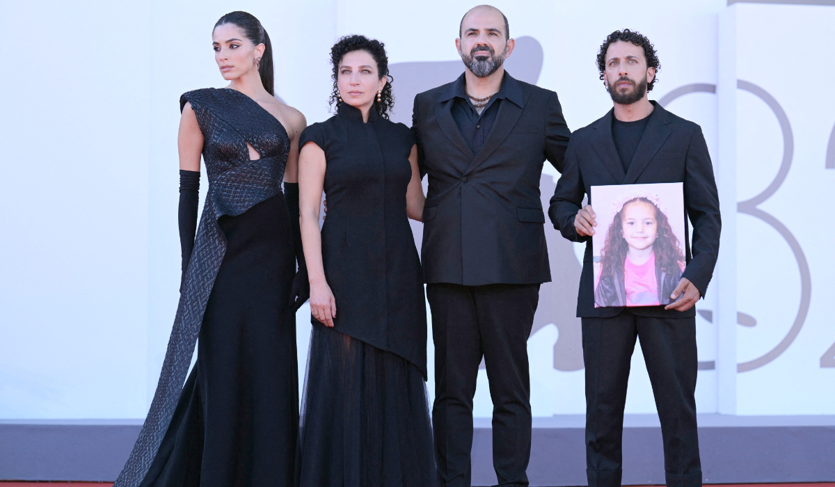 From left: Actress Saja Kilani, actress Clara Khoury, Israelian actor Amer Hlehel and actor Motaz Malhees, pose with a portrait of late Palestinian girl Hind Rajab, during the red carpet for the movie "The Voice of Hind Rajab" presented in competition at the 82nd International Venice Film Festival, at Venice Lido on September 3, 2025. (AFP)
