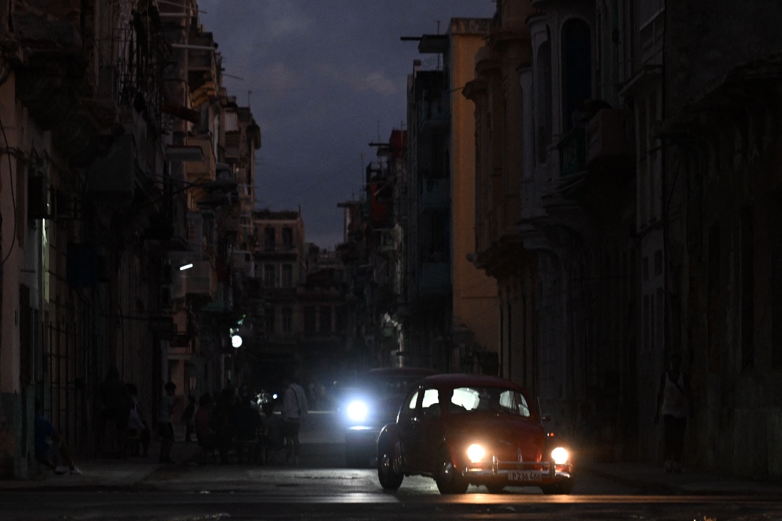 People transit on a street without power during a nation wide blackout in Havana, Cuba. (AFP)