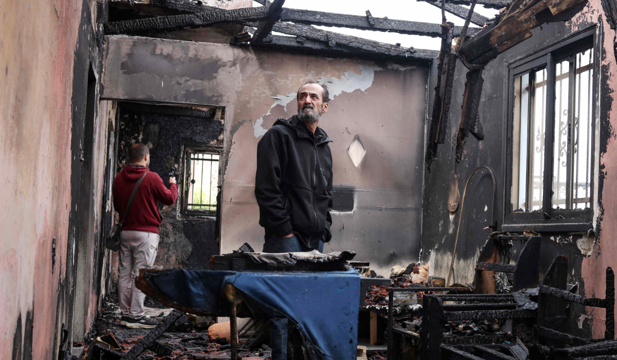 A Palestinian man inspects the remains of his burnt-out family home following a reported attack by Israeli settlers in the village of Fandaqumiya, southwest of Jenin, in the Israeli-occupied West Bank on March 22, 2026. (AFP)
