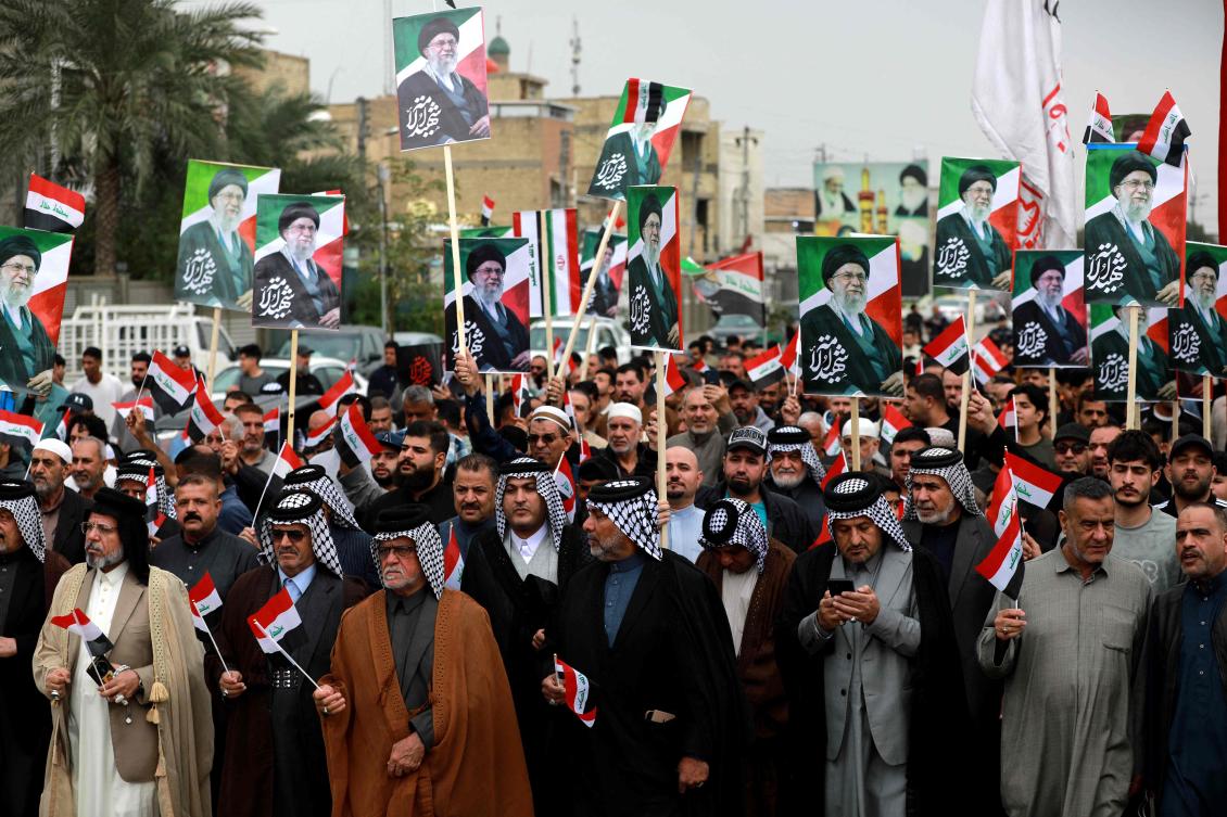 Iraqis rally in support of neighboring Iran in the Al-Aamil district of Baghdad on Sunday. Targets linked to both sides in the conflict have been hit in the Iraqi capital. (AFP)