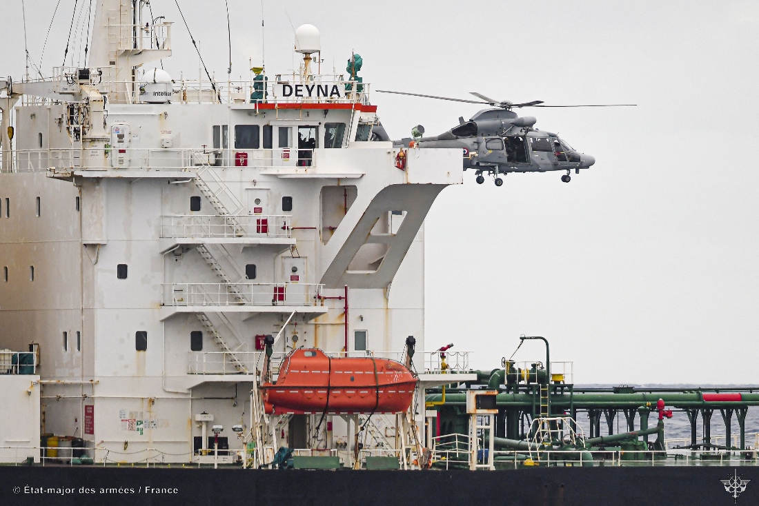 This handout photo taken and released by the Etat Major des Armees shows a helicopter of the French Navy hovering over the Mozambican-flagged oil tanker Deyna during an interception operation in the western Mediterranean Sea.