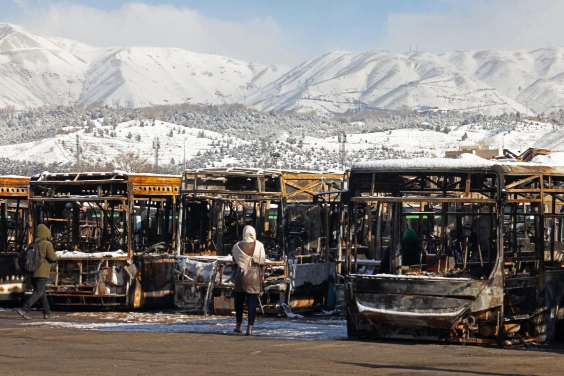 Above, parked buses that were burnt at a depot during recent public protests, in Tehran on Jan. 21, 2026. (AFP file photo)