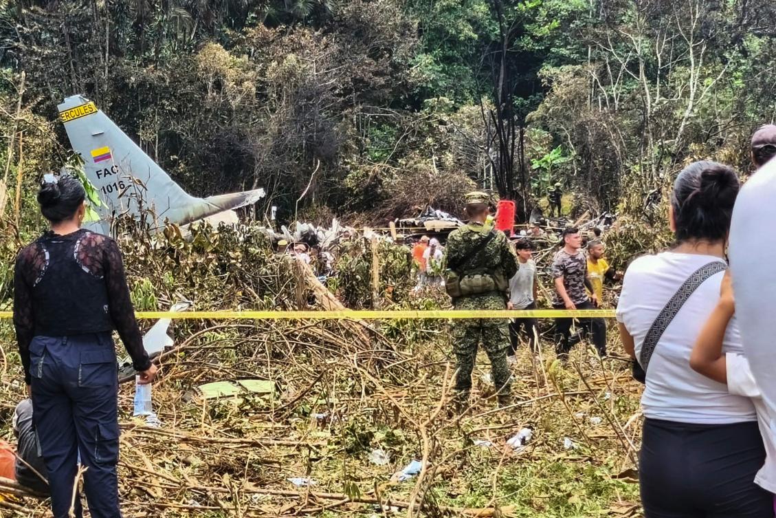People and soldiers stand near debris from an Air Force Hercules that crashed during takeoff, in Puerto Leguizamo, Colombia, near the southern border with Ecuador, March 23, 2026. (AFP)