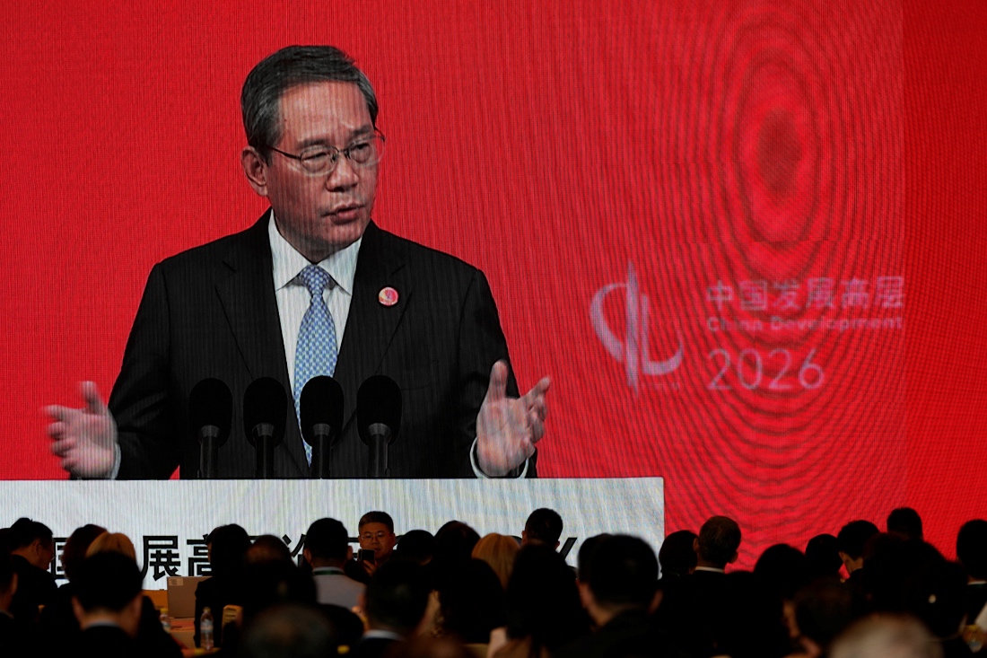 Chinese Premier Li Qiang on a big screen live broadcasting his speech at the opening of the China Development Forum 2026 held at the Diaoyutai State Guesthouse in Beijing, China. (Pool/Reuters)