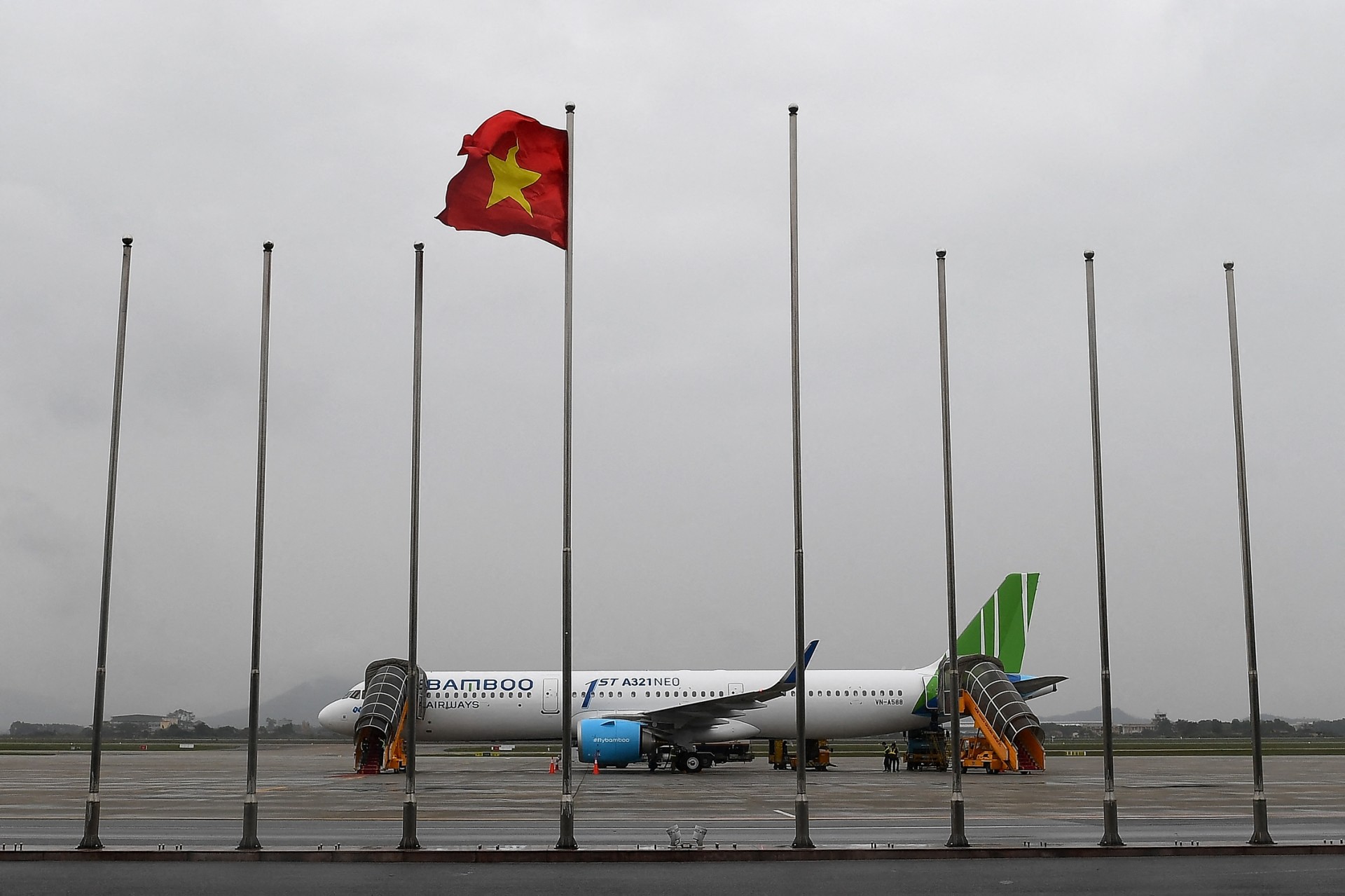 Vietnamese flag flutters as an Airbus A321Neo airplane of Vietnam's newly launched Bamboo Airways is parked on the runway in Hanoi, Vietnam. (AFP)