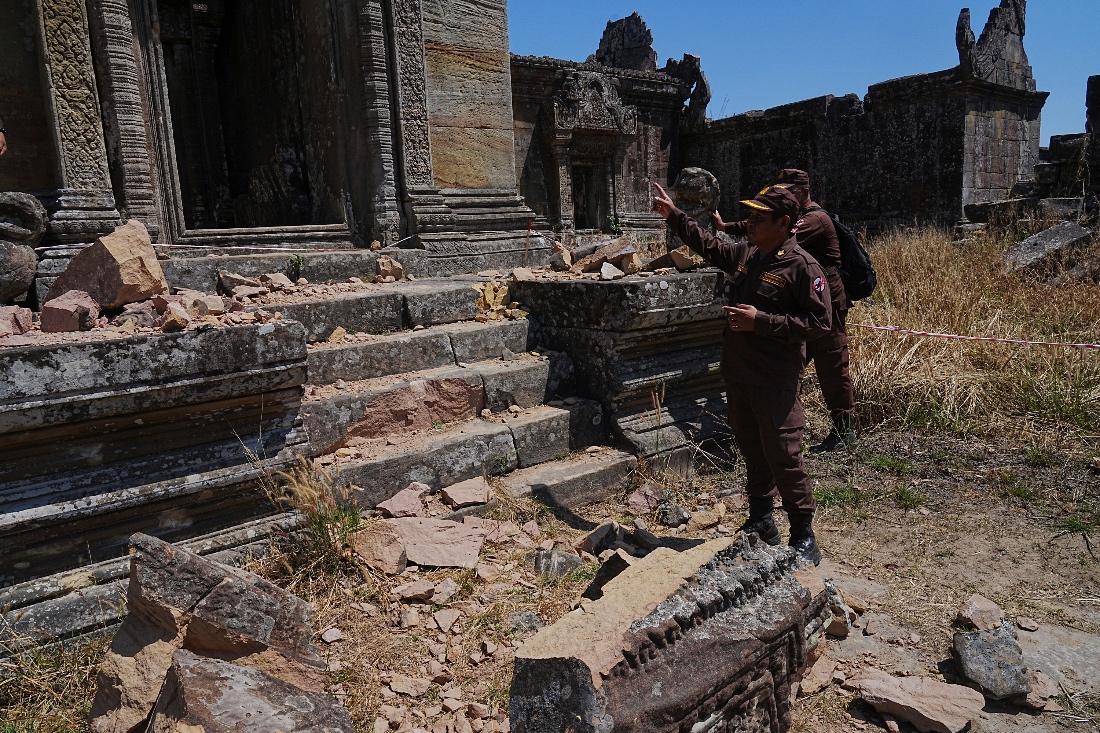 Cambodian Mine Action Center, CMAC, members stand near a temple damaged during border clashes with Thailand, at Preah Vihear province, Cambodia. (AP)