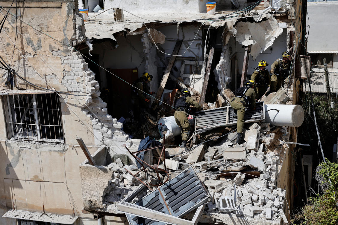 Israeli soldiers inspect the site of a damaged building following barrages of Iranian missiles, amid the US-Israeli conflict with Iran, in Tel Aviv, Israel, March 22, 2026. REUTERS/Amir Cohen