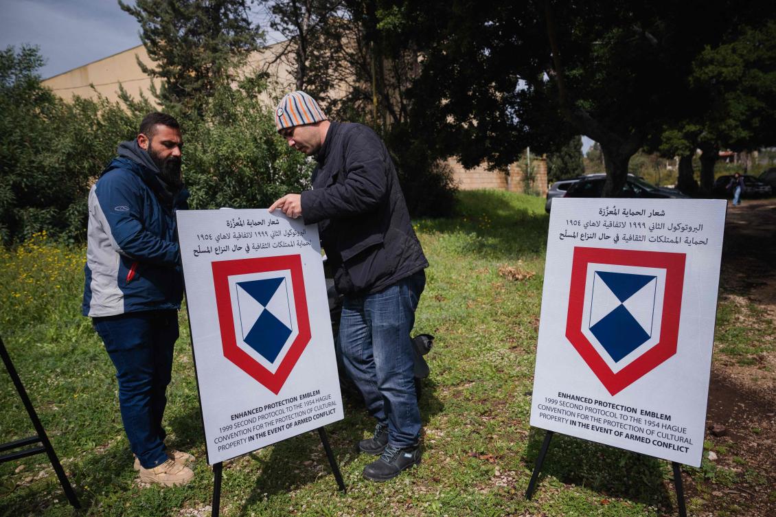 Museum employees place Enhanced Protection Emblems, a special symbol used under international humanitarian law to protect critical sites during armed conflict, at the archaeological site of the Roman hippodrome in the Southern Lebanese city of Tyre. (AFP)