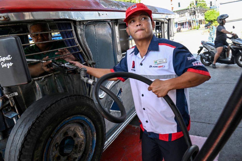 Jeepney driver Eric Helera refuels his vehicle with diesel at a fuel station in Manila on March 23, 2026. (AFP)