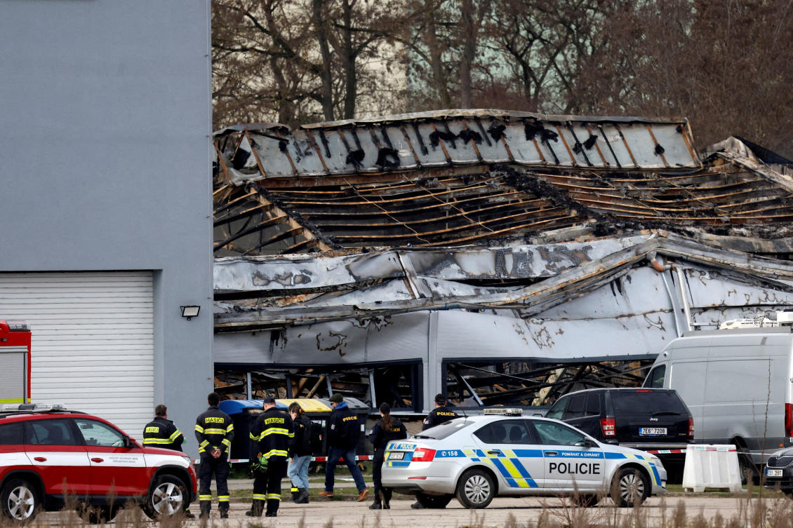 Police officers and a firefighters stand in front of a burned production hall at an industrial area in Pardubice, Czech Republic, Mar. 20, 2026. (Reuters/File)