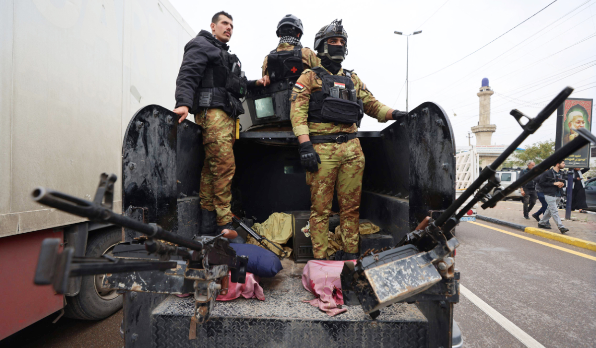 Members of Iraqís Hashed al-Shaabi, an alliance of factions now integrated into the regular army, guard the streets during the funeral for members of the Hashed al-Shaabi Forces in Baghdad on March 24, 2026. (AFP)