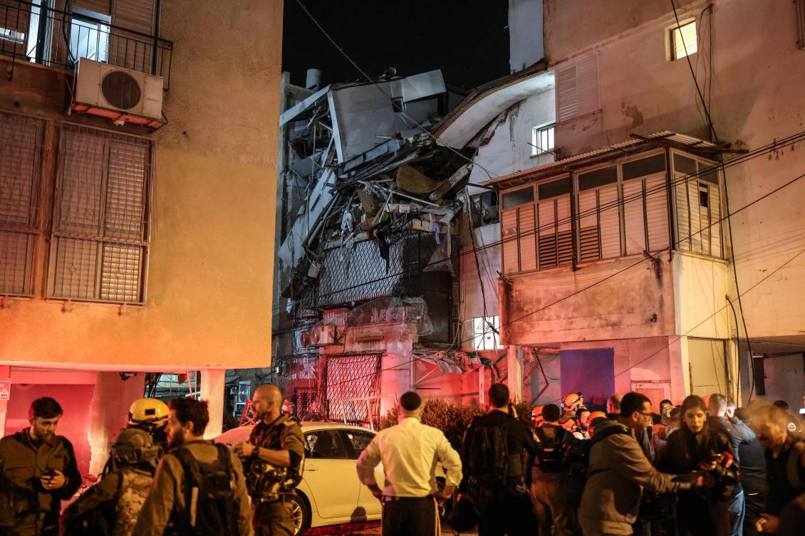 Security forces and first responders gather next to a damaged building at a site struck by a projectile in Bnei Brak, on the eastern outskirts of Tel Aviv, on Mar. 24, 2026. (AFP)