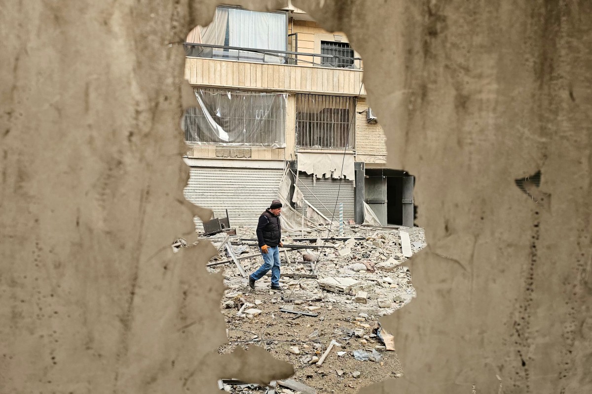 A man walks along a street strewn with building debris at the site of an overnight Israeli airstrike that targeted a neighborhood in Beirut’s southern suburbs, March 25, 2026. (AFP)