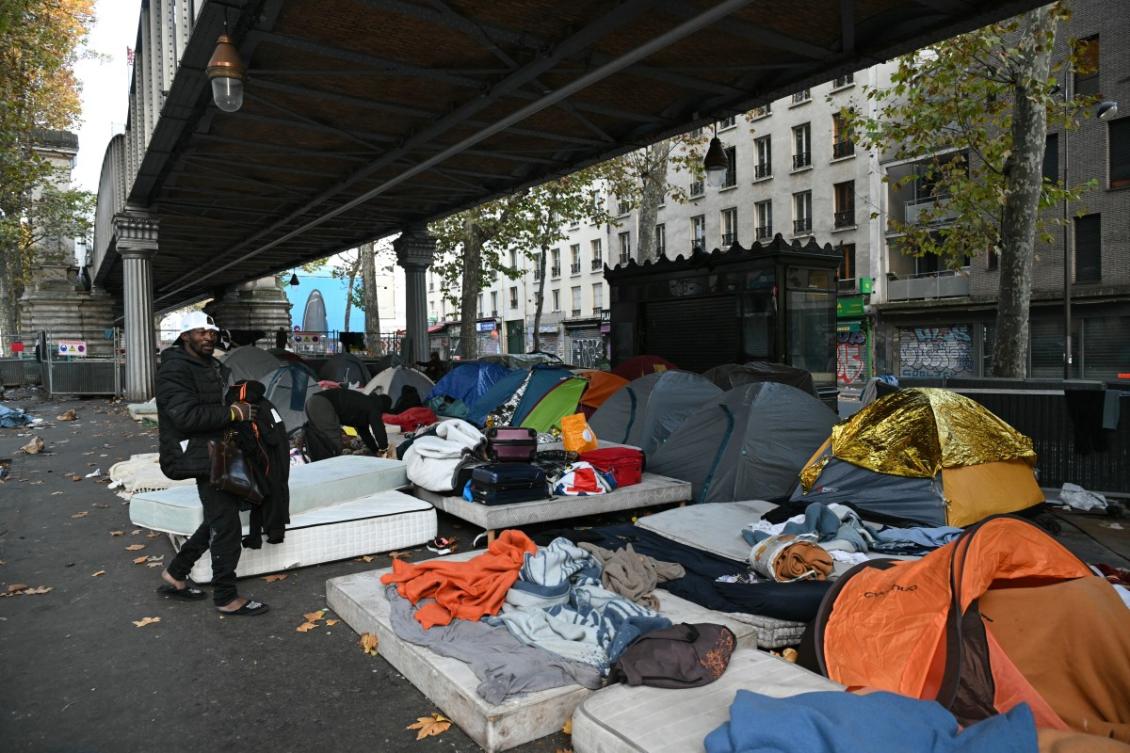 A migrant walks by a makeshift camp set up under the overhead railway line at Stalingrad metro station as police prepare to clear away the encampment in Paris early on November 5, 2025. (AFP)