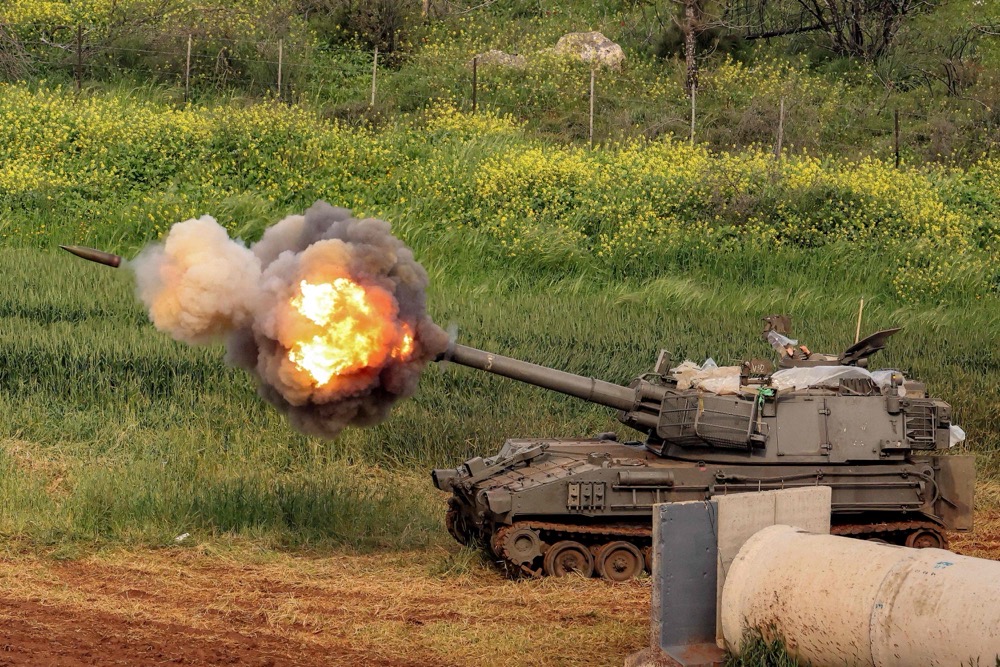 An Israeli tank on Thursday fires rounds toward southern Lebanon from a position in the upper Galilee in northern Israel near the border. (AFP)