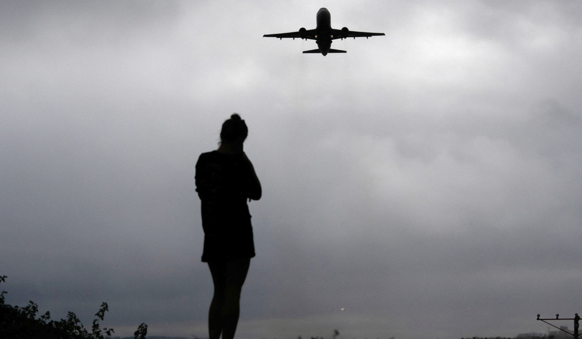 runner watches as a plane takes off from Reagan Washington National Airport as the U.S. government shutdown continues in Arlington, Virginia, U.S., October 8, 2025. (REUTERS)