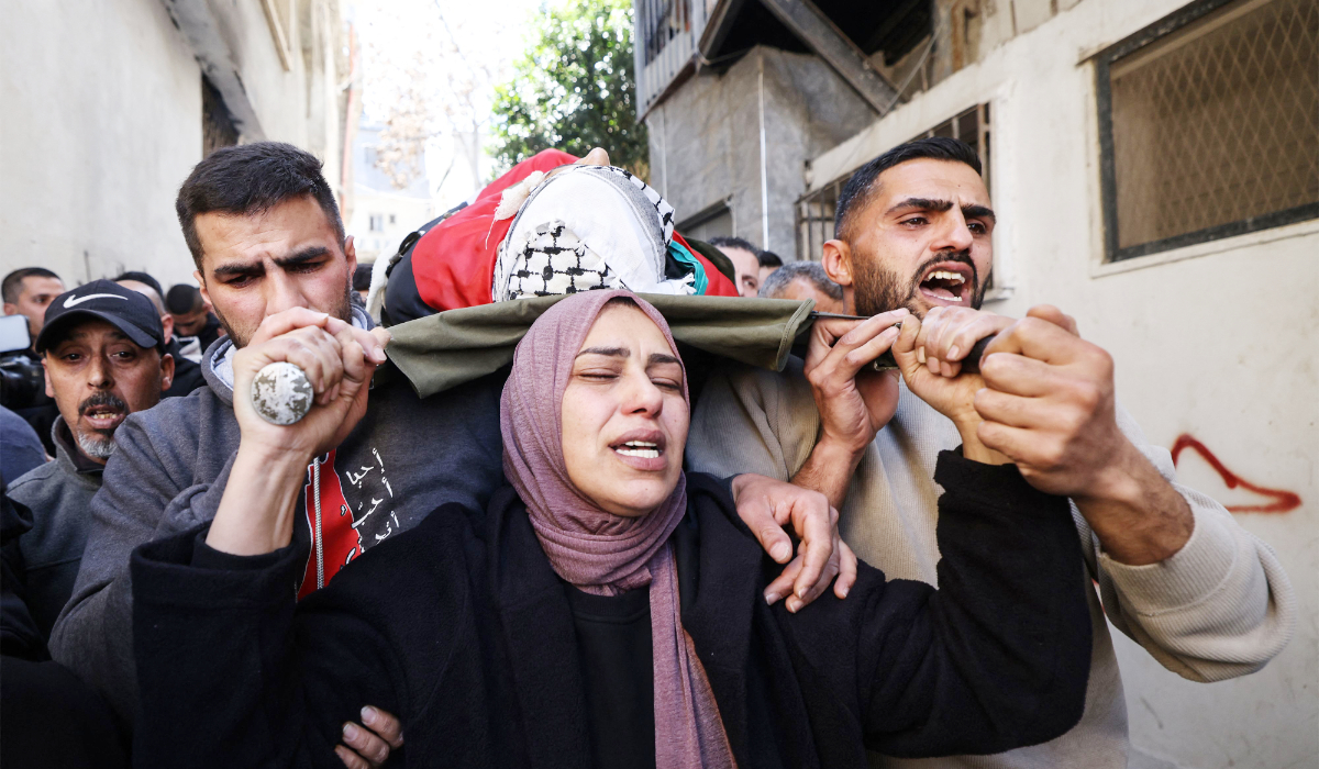 Hanan, the mother of Adam, a 15-year-old Palestinian who was killed by Israeli security forces during a military raid the previous night in the al-Dheisheh refugee camp near the occupied West Bank city of Bethlehem, carries her son's body during his funeral on March 28, 2026. (AFP)