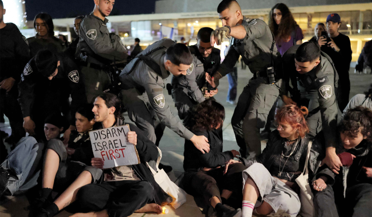 Israeli border guards attempt to remove protesters from the weekly-war demonstration in Tel Aviv on March 28, 2026 amid safety concerns over possible projectile attacks. (AFP)