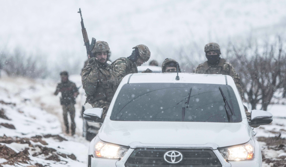 Syrian soldiers sit in a pick-up truck as they make their way through the country’s mountainous Qalamoun region, near the border with Lebanon, during a patrol to secure the frontier and prevent smuggling operations on January 1, 2026. (AFP)
