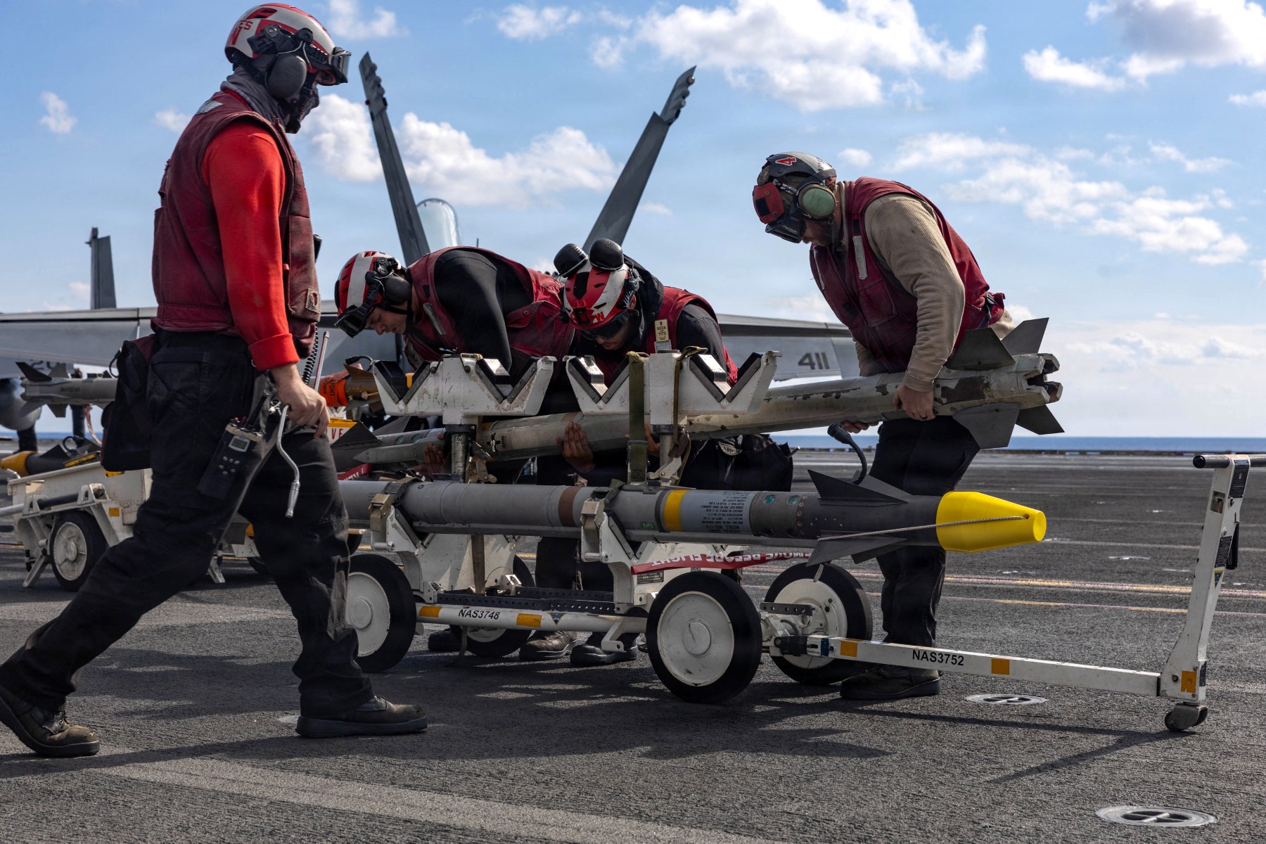 Above, US sailors hande ordnance on the flight deck of USS Gerald R. Ford while operating in the Eastern Mediterranean Sea on March 2, 2026. (US Navy/AFP)