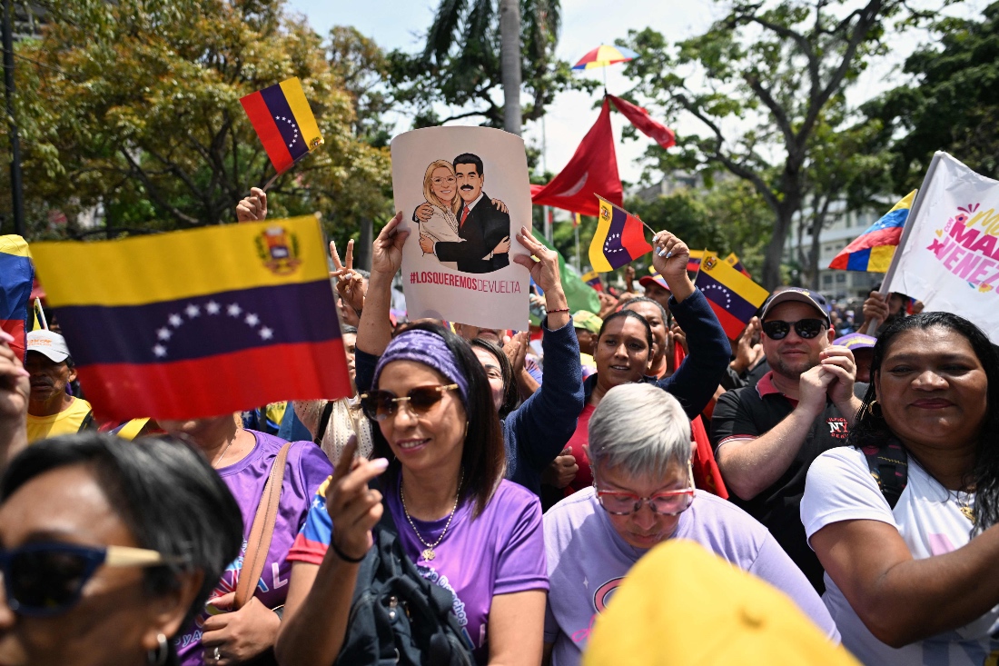 Supporters of Venezuela's ousted president Nicolas Maduro demonstrate with a poster of him and his wife Cilia Flores reading "We want them back" and Venezuelan national flags in Caracas, Venezuela. (AFP)