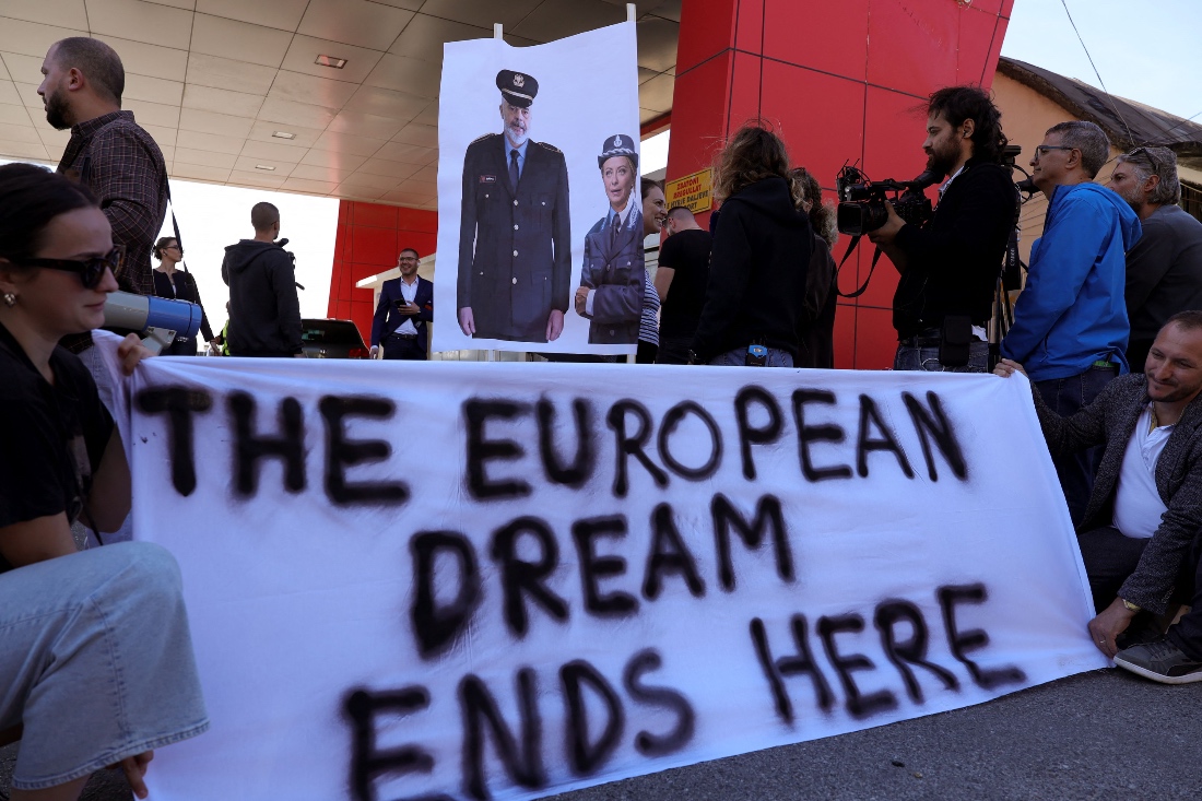 A group of civil rights activists gather in protest, after the first group migrants intercepted in Italian waters, arrived at Shengjin port in Albania. (AFP)