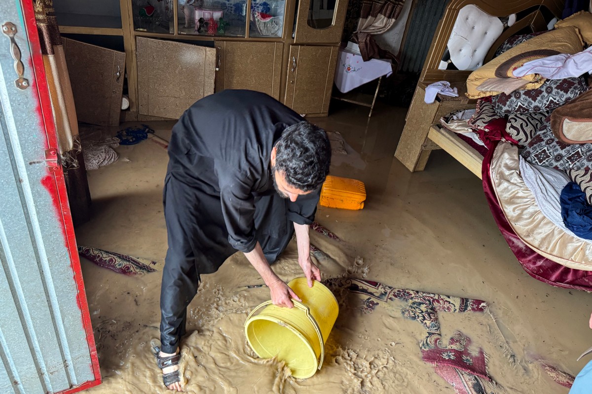 An Afghan man removes floodwaters from his deluged house after rainfall in Kandahar, Afghanistan. (AFP)