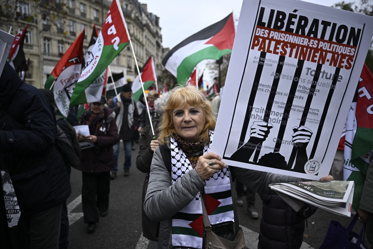 A demonstrator holds a slogan which reads “Liberation of Palestinian political prisoners” during a rally in solidarity with Palestinians in Paris. (File / AFP)