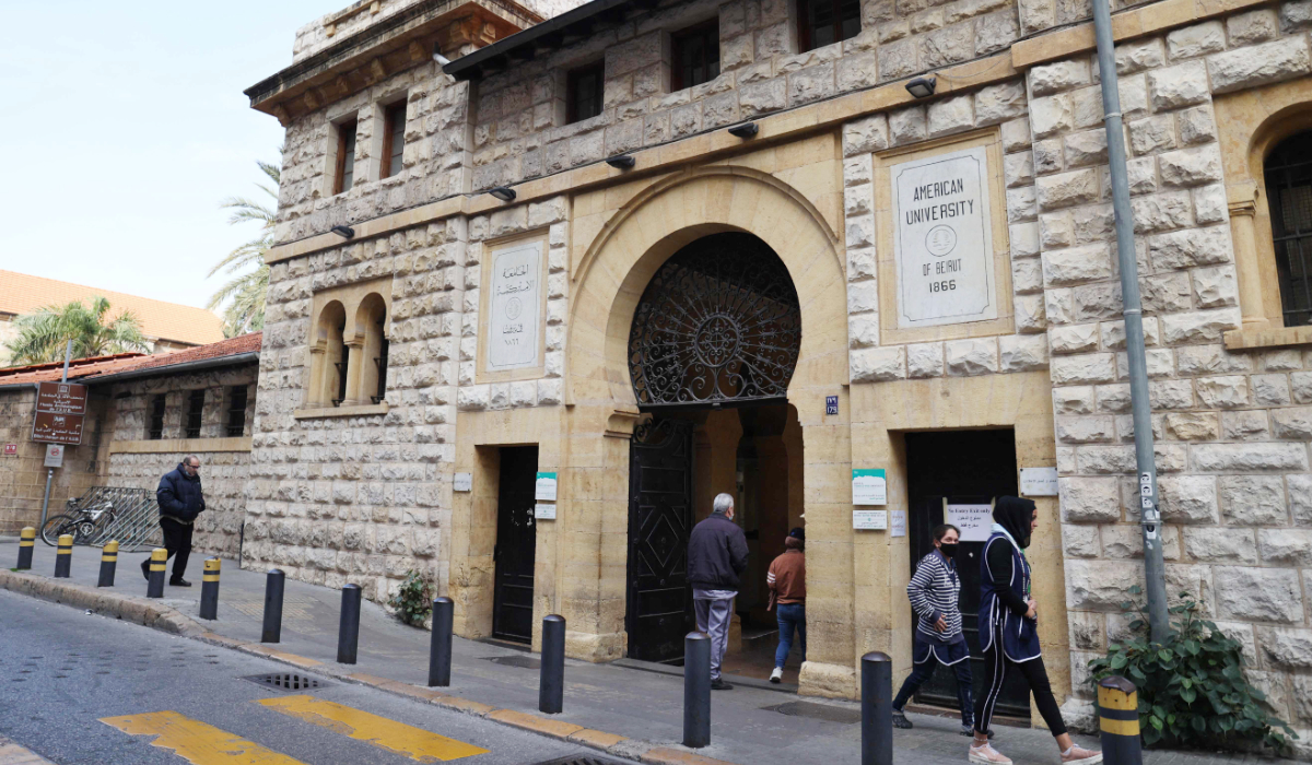 People walk past the main gate to the campus of the American University of Beirut (AUB) in the centre of Beirut on January 13, 2022. (AFP)