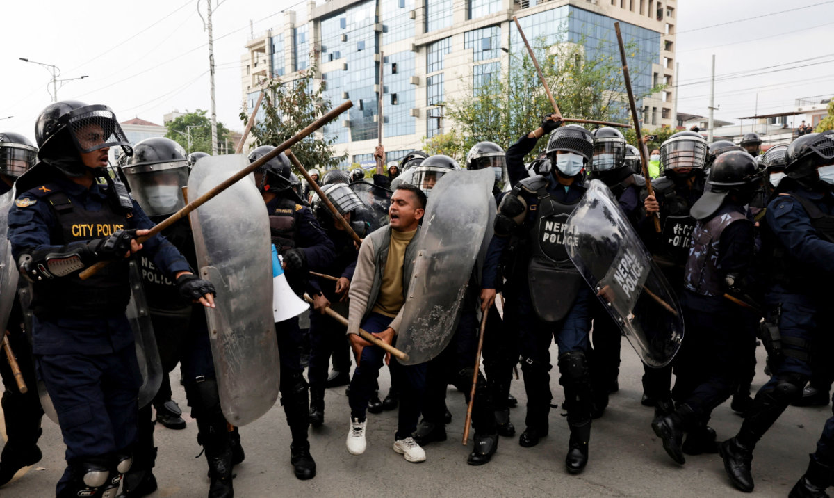 Police officials clash with a supporter of former Prime Minister K. P. Sharma Oli during a protest on Sunday in Kathmandu. (Reuters)