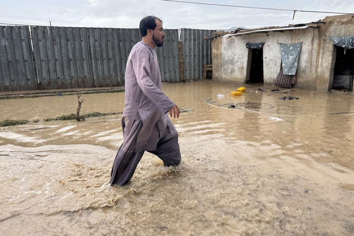 An Afghan man wades across floodwaters in a yard, after rainfall in Kandahar on March 25, 2026. (FILE/AFP)