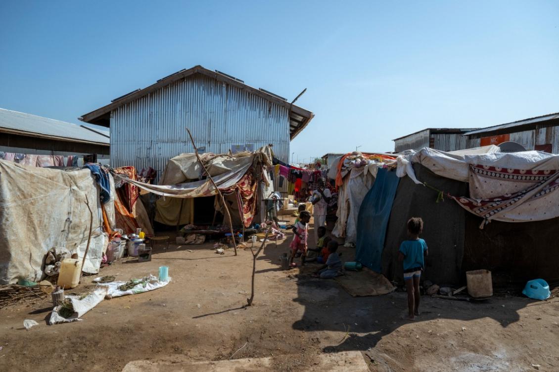 Young refugees and returnees gather in front of makeshift shelters at the Renk Transit Center in Renk, South Sudan, on November 18, 2025. (AFP)