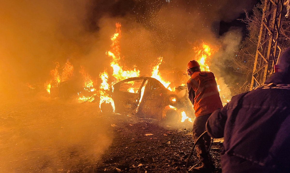 Rescue workers battle flames engulfing vehicles at the site of an Israeli airstrike in Beirut on Wednesday. (AP)