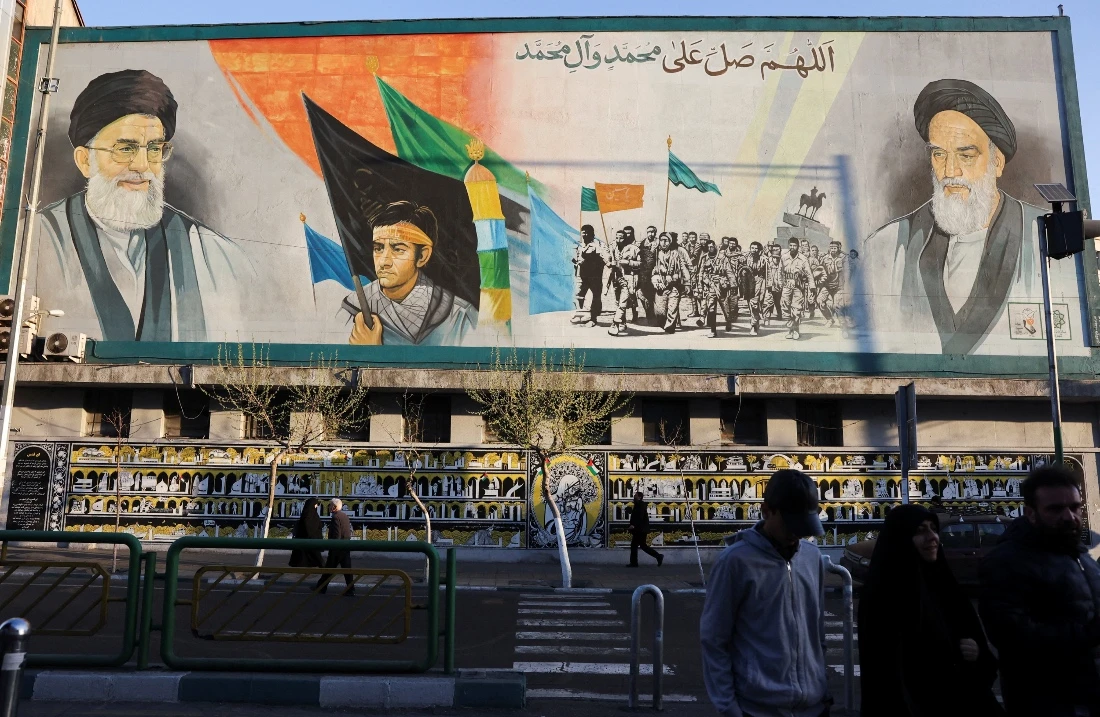 People walk near a mural featuring images of Iran's Supreme Leader Ayatollah Ali Khamenei and the leader of Iran's 1979 Islamic Revolution Ayatollah Ruhollah Khomeini in Tehran, Iran. (Reuters)