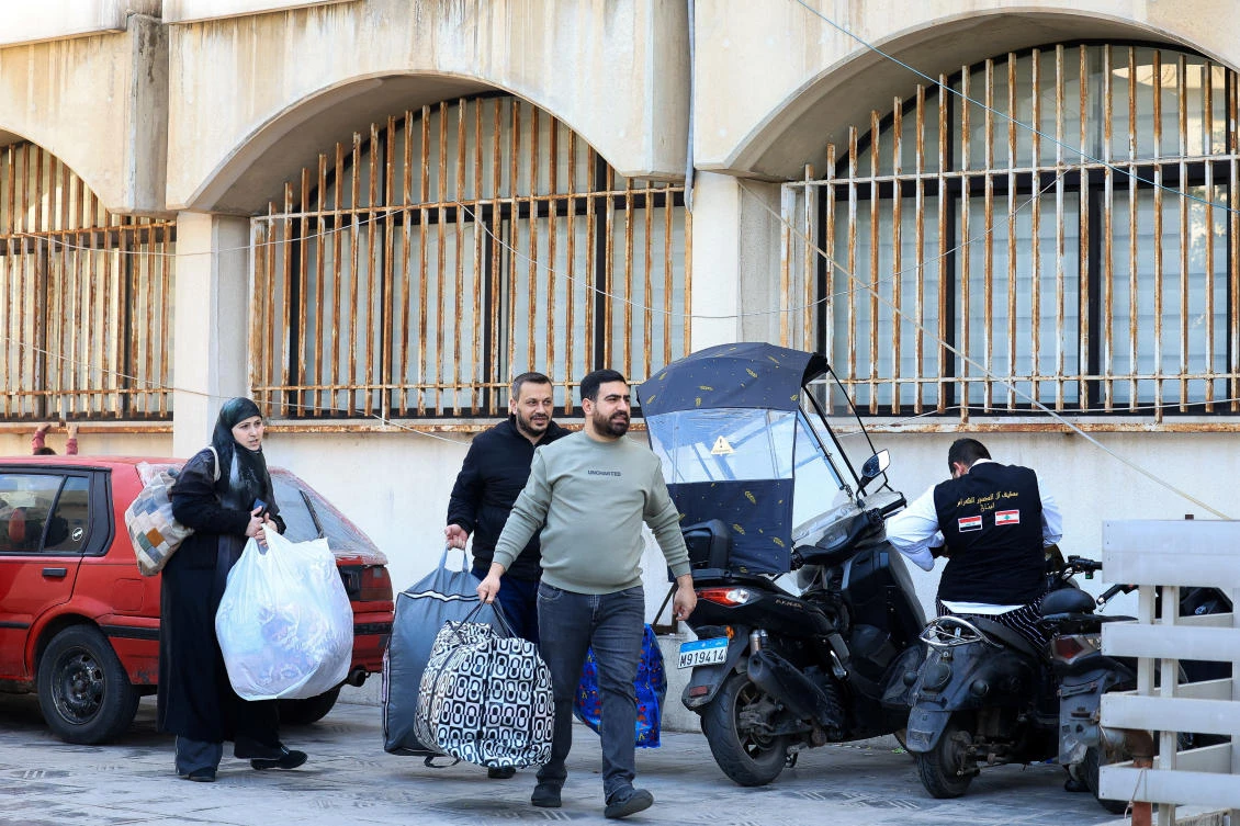 Displaced people walk outside a school-turned-shelter in Beirut, Lebanon on March 3, 2026. (Reuters)