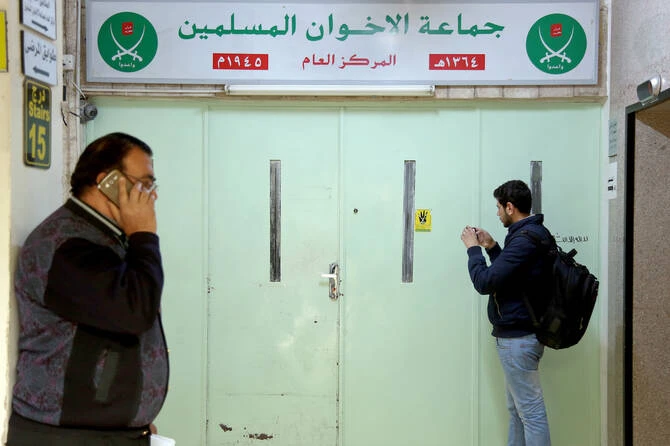 A man photographs the main entrance of the original Muslim Brotherhood office, that is sealed with official wax after it was raided and shut down by police, in Amman, Jordan, Wednesday, April 13, 2016. (AP)