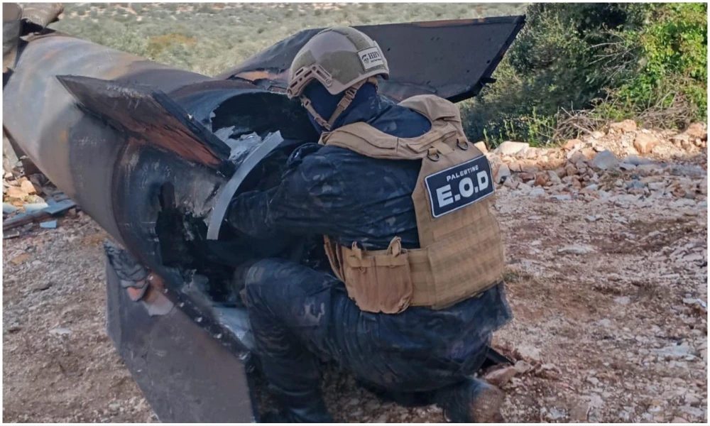 A Palestinian security officer handles a piece of an Iranian missile that fell in a town in the West Bank. (Wafa)